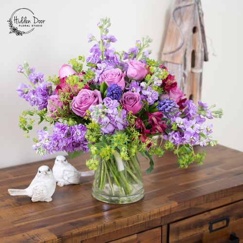 Lavender roses purple stock and blue hyacinth with bupleurum in a glass vase from Durham flower studio