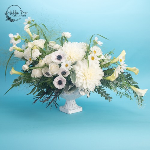 White dahlias anemones and calla lilies with daisies in a classic white urn by Durham floral studio